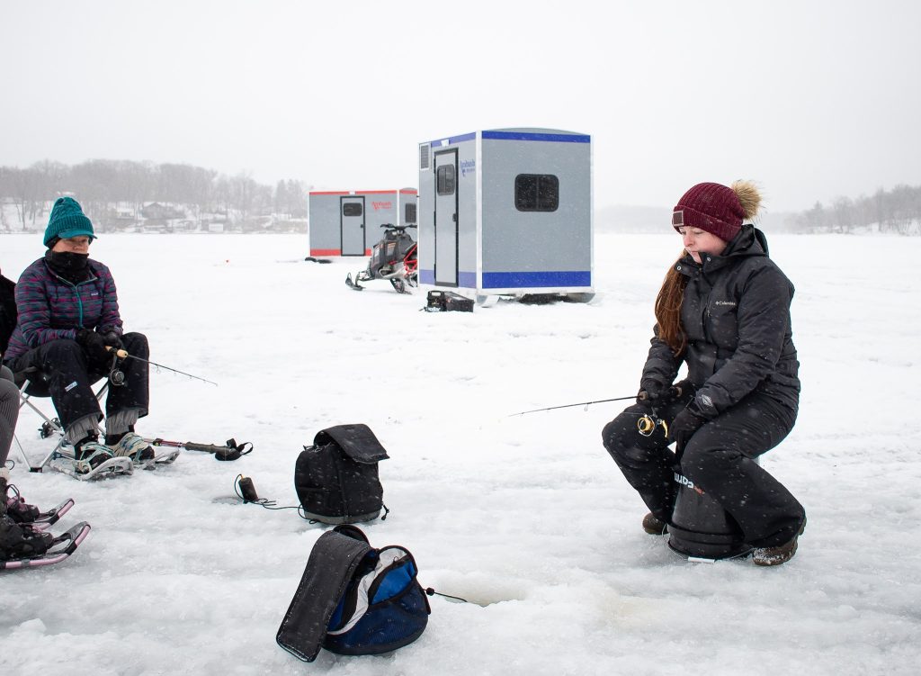 Woman Ice Fishing with Ambush Ice House In The Background