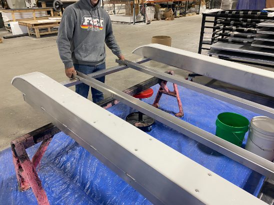 man working on chassis frame for a skid house assembly