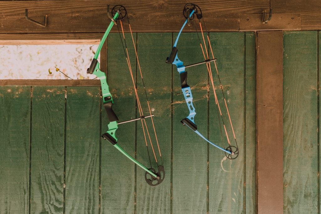 pexels-rodnae-productions-6655480 two compound bows hanging